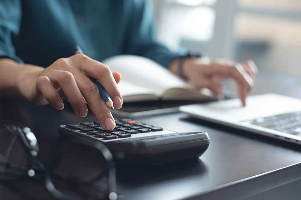 Foto: Person tippt auf Taschenrechner
